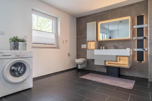 a bathroom with a washing machine and a sink at - DESIGN & STYLE - Modern House with terrace & garden in Wesel