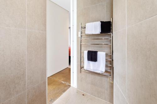 皮哈的住宿－Piha Pool Pad - Piha Holiday Home，一间带毛巾架和镜子的浴室
