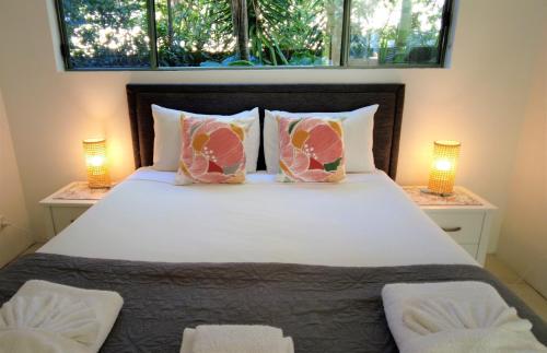 a bedroom with a large white bed with two lamps at Noosa River Retreat Holiday Apartments in Noosaville