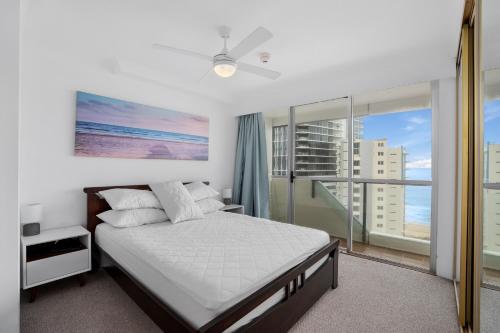 a bedroom with a bed and a large window at Baronnet Apartments in Gold Coast