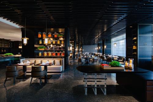 un restaurante con mesas y sillas y un bar en Empark Grand Hotel Beijing en Beijing