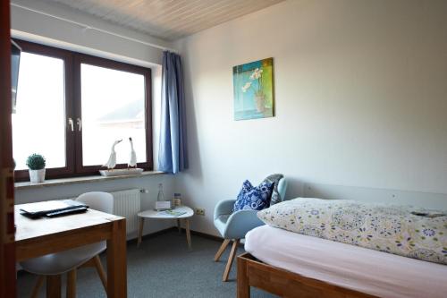 a bedroom with a bed and a desk and a window at Room and kitchen im Katerberg in Ahlefeld