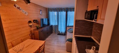 ein kleines Zimmer mit einer Küche und einem Wohnzimmer in der Unterkunft Appartement résidence L'Ours blanc chez Jimmy in Huez
