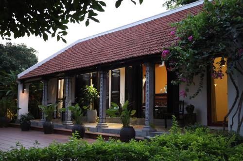 a building with potted plants in front of it at Thom's House in Ninh Binh