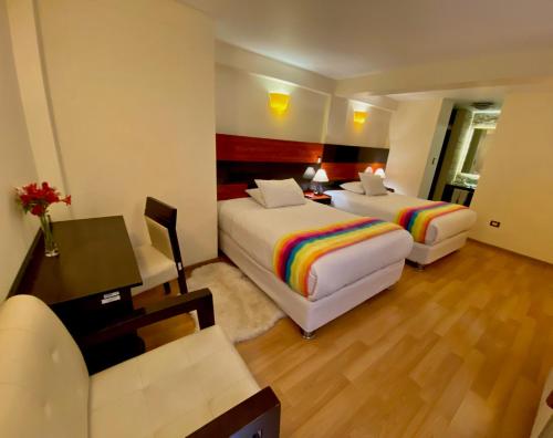 a hotel room with two beds and a desk and a couch at Mistico San Blas Boutique in Cusco