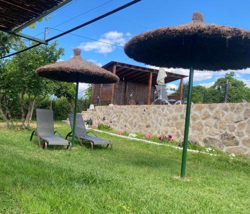 two chairs and two umbrellas in the grass at La Lagunilla Golf in Candeleda