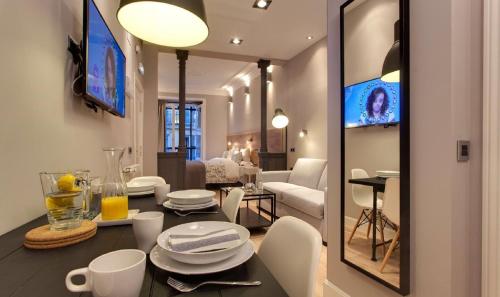 a dining room and living room with a table and chairs at Suites You Platinum in Madrid