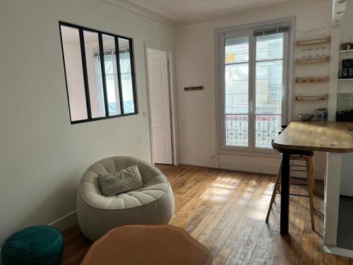 a living room with a chair and a table at Charming 2 bedrooms flat near Trocadéro in Paris