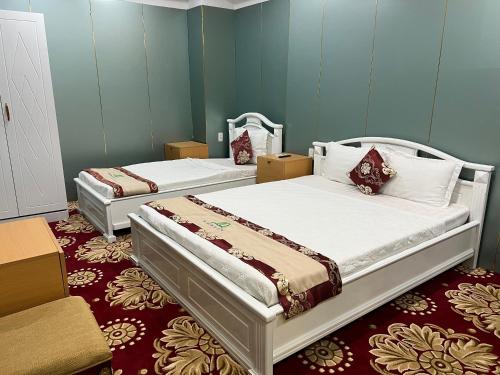 two beds in a room with blue walls at Nhat Quy Hotel in Tây Ninh