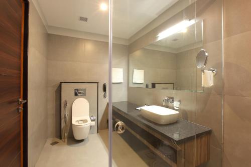 a bathroom with a toilet and a sink and a mirror at HOTEL MARIA PARK in Mūvattupula