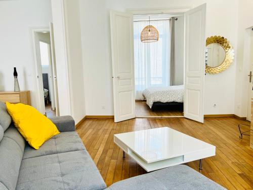 uma sala de estar com um sofá e uma mesa de centro em CHIC Appartement Type 4 / Parking Privé em Reims