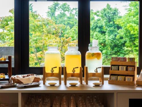 una mesa con tres botellas de miel y una ventana en Beppu Fuga, en Beppu