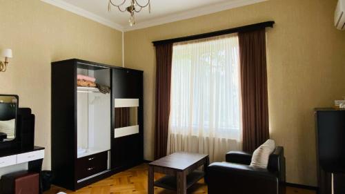 a living room with a tv and a window at Neli & Zaal Guest House in Tʼelavi