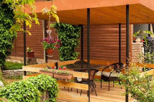 a patio with a table and chairs on a wooden deck at Neli & Zaal Guest House in Tʼelavi