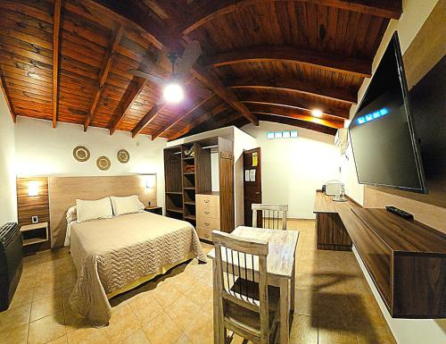 - une chambre avec un lit et une télévision à écran plat dans l'établissement Posada Aitue, à Villa General Belgrano