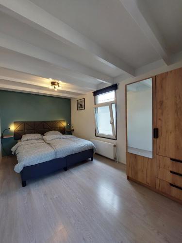 a bedroom with a bed and a large window at Stelle Maris, Nice place in Heinkenszand, 2 bedrooms, outdoor swimming pool, WIFI smart TV and privacy in Heinkensand
