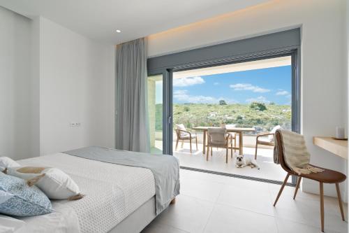 sypialnia z łóżkiem oraz balkon ze stołem w obiekcie Le Mont Blanc w mieście Kounoupidiana