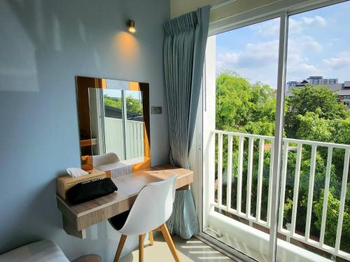 a room with a desk and a large window at 98 Tower Chiang Mai in Chiang Mai