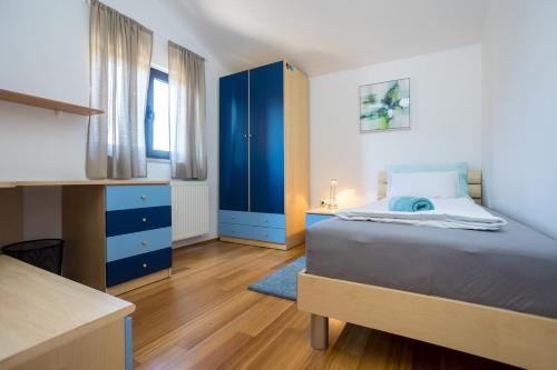 a bedroom with a bed and a blue cabinet at APARTMANI BEBA in Omišalj