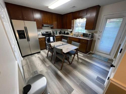 a kitchen with a table and a refrigerator at NEW King Beds, 86 inch RokuTV, and Massage at the Comfort Haven in Commerce