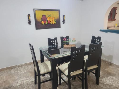 ein Esszimmer mit einem Tisch mit Stühlen und einem Gemälde in der Unterkunft Vivienda Turistica Cattleya in Filandia