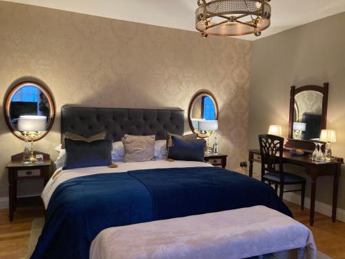 una camera da letto con un grande letto blu con due specchi di Barrow Lodge a Tralee