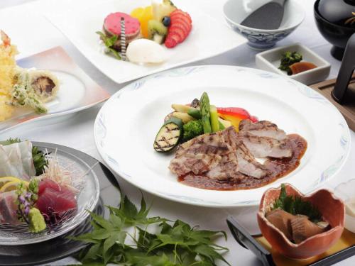 a table with several plates of food on it at Nichinankaigan Nango Prince Hotel in Nichinan