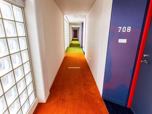 a long hallway with a blue door and a green corridor at Nichinankaigan Nango Prince Hotel in Nichinan