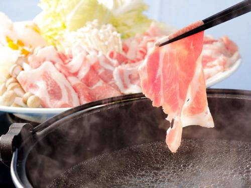 a piece of meat is being cooked on a grill at Nichinankaigan Nango Prince Hotel in Nichinan