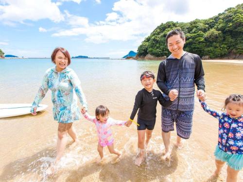 a family walking in the water on the beach at Nichinankaigan Nango Prince Hotel in Nichinan
