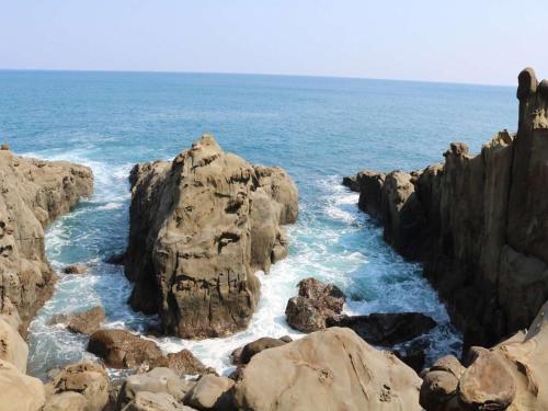 a view of the ocean with rocks in the water at Nichinankaigan Nango Prince Hotel in Nichinan