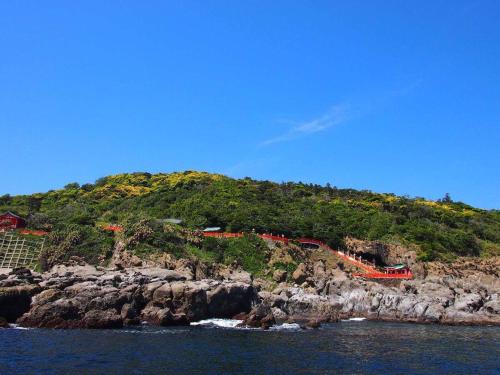 an island with red fences on a rocky hill at Nichinankaigan Nango Prince Hotel in Nichinan