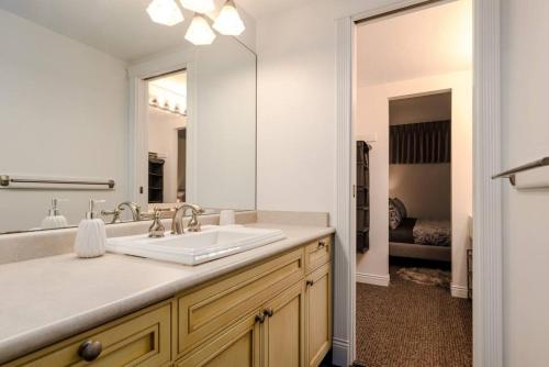 a bathroom with a sink and a large mirror at Patagonia 2 Bed 2 Bath with Private Hot Tub in Whistler