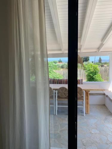 a view of a patio with a table and a window at Maison Filo&Sofia in Porto Heli