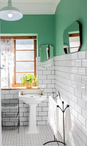 a bathroom with a white sink and green walls at Boho Chic Apartment Stellenbosch in Stellenbosch