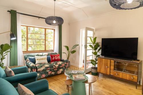 een woonkamer met een bank en een tv bij Boho Chic Apartment Stellenbosch in Stellenbosch