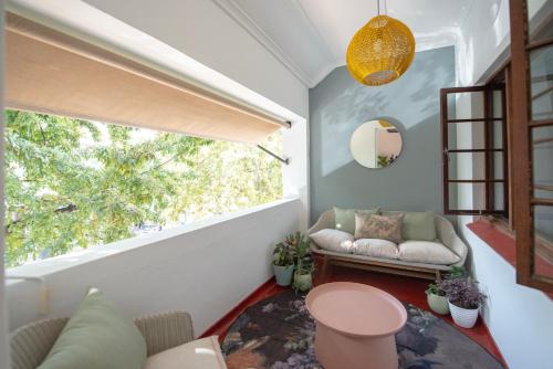 a living room with a couch and a large window at Boho Chic Apartment Stellenbosch in Stellenbosch