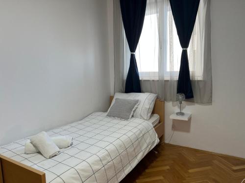ein kleines Schlafzimmer mit einem Bett und einem Fenster in der Unterkunft Apartment Gabi in Split