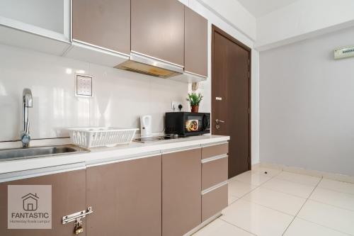 a kitchen with a sink and a microwave at Regalia Residence @ KLCC View Sky Pool by MC in Kuala Lumpur
