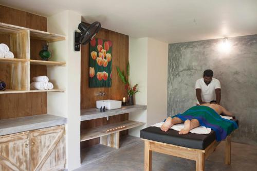 a man laying on a bed in a room at Ratnakara in Dondra East