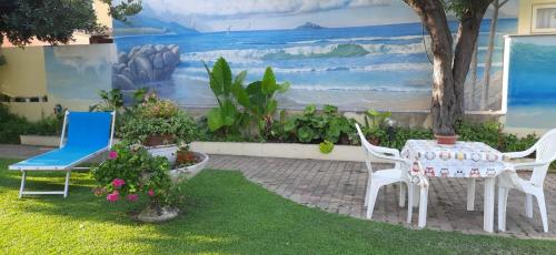 a patio with a table and chairs and a mural at Casa Vacanze Arba Girasole in Girasole