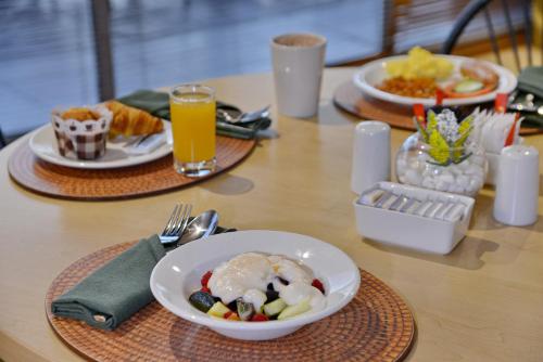 a table with plates of food and a bowl of fruit at Road Lodge Southgate in Southgate