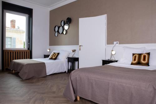 um quarto de hotel com duas camas e uma janela em L'Aparté em Salles