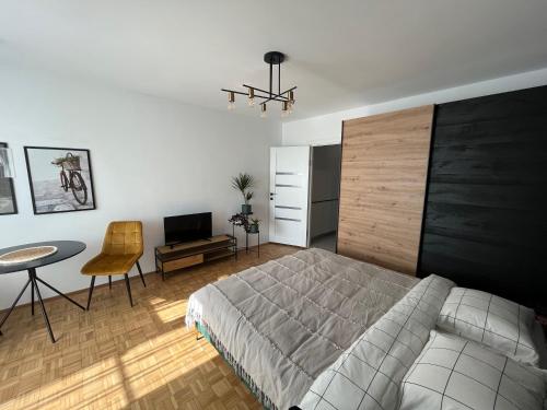 - une chambre avec un lit, une table et une chaise dans l'établissement C & A apartments, à Cluj-Napoca