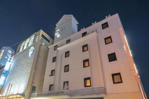 un edificio blanco con un reloj encima en Aank Hotel Cheongju 1, en Cheongju