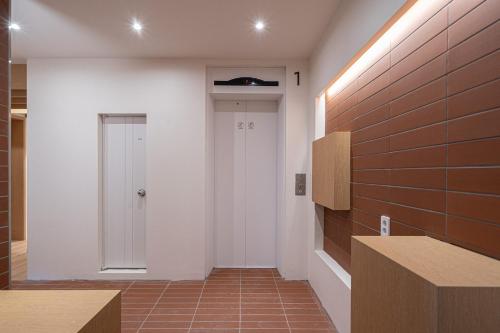 a hallway with a white wall and a door at Aank Hotel Cheongju Uam 1st in Cheongju