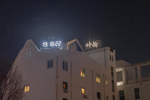 un edificio con un reloj encima por la noche en Aank Hotel Cheongju 1, en Cheongju