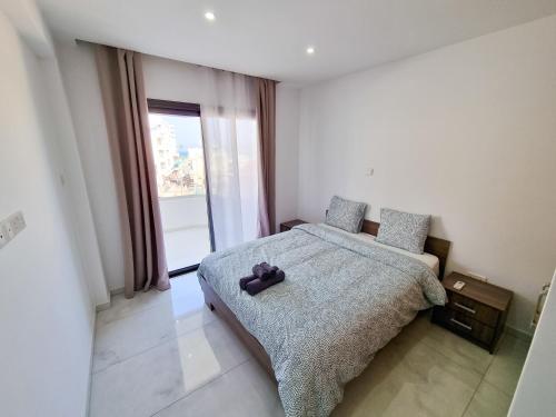 ein Schlafzimmer mit einem Bett mit einem Teddybär drauf in der Unterkunft Sea Bay Apartment in Larnaka