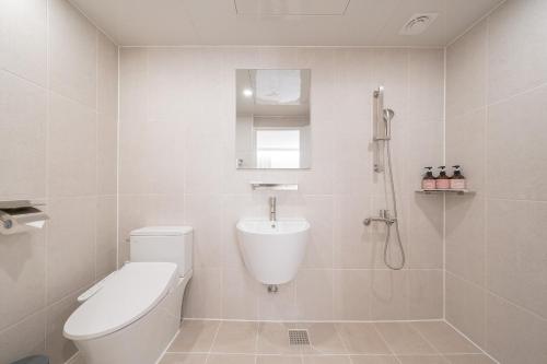 a white bathroom with a toilet and a shower at Aank Hotel Cheongju Uam 1st in Cheongju