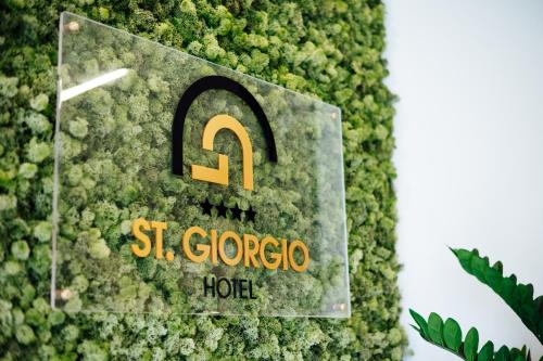 爾聖焦爾焦堡的住宿－聖喬治酒店，绿墙,上面有读Stegrargios酒店的标志